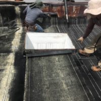 men repairing a flat roof
