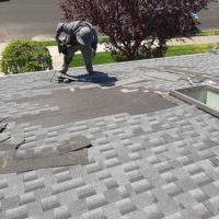 a man repairing and replacing roof shingles