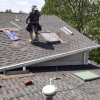 a man repairing a roof and skylight