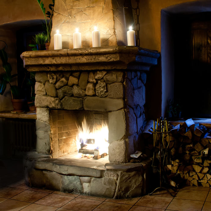 Fireplace room. Chimney, candles and woodpile. Chimney place.
