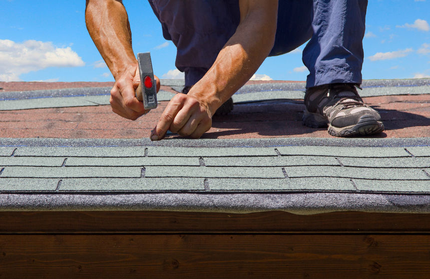 gardener renew roof of summer garden house with tar paper shingles