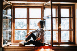 Woman sitting on brown wooden window frame