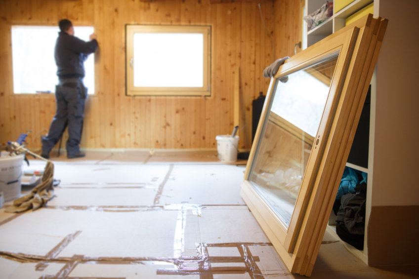 Worker installing new wooden windows