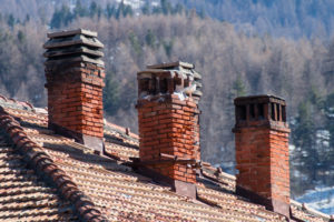 three old damaged chimneys made of bricks